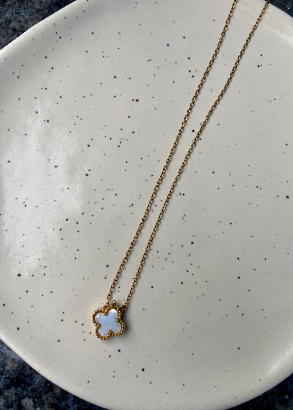  White clover necklace on a white surface